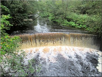 The curved weir upstream of the footbridge